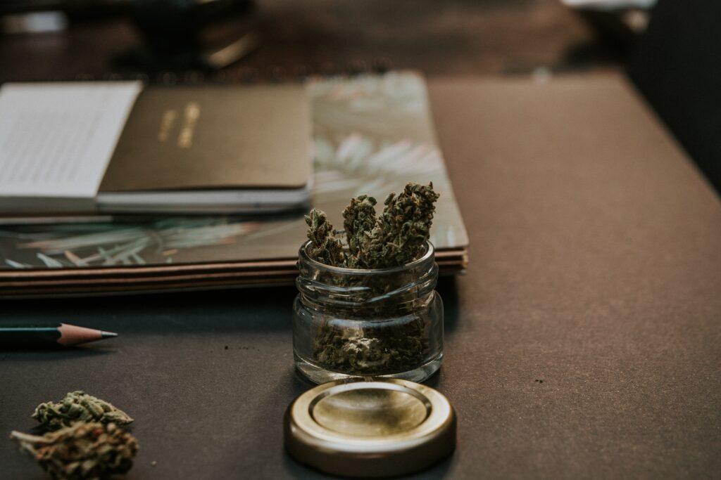 marijuana in a small jar on a writer's desk